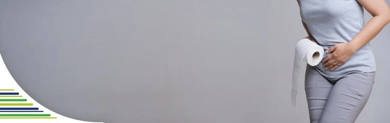 Těhotná žena drží na záchodovém papíře břicho kvůli průjmům.