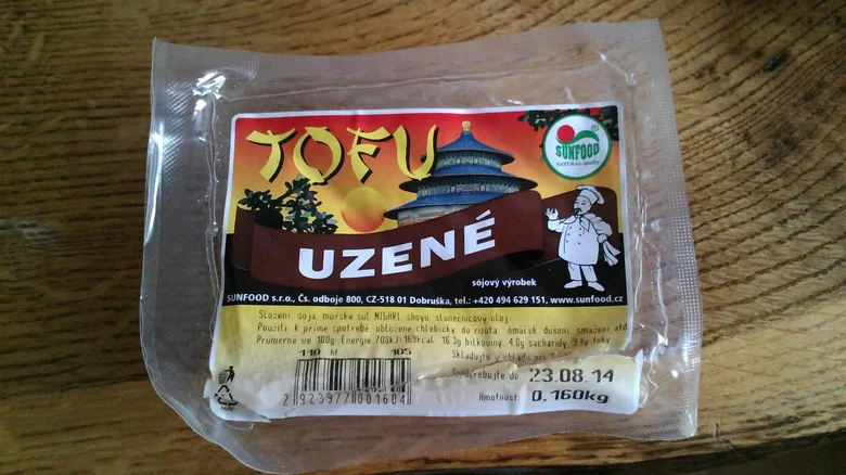 Balíček uzeného tofu značky Sunfood na dřevěném povrchu.