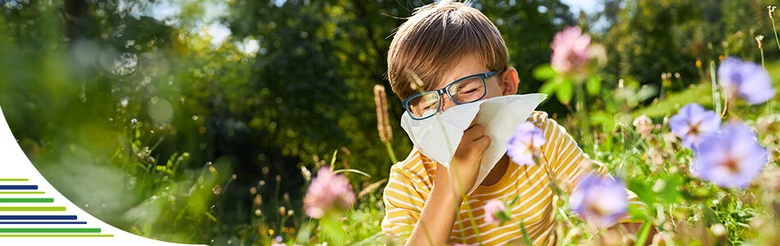 Boy sneezing in flowers