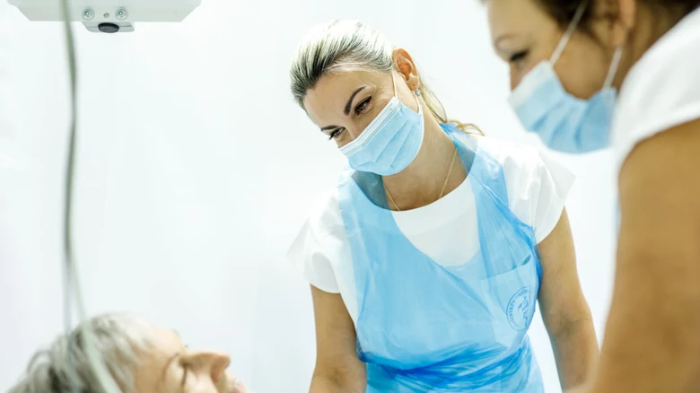 Lékařské profesionály vyšetřují pacienta v klinickém prostředí.