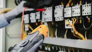 Elektrikář měří napětí v rozvaděči pomocí multimetru.