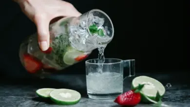 Lidé nalévají osvěžující nealko drink s ovocem do sklenice.