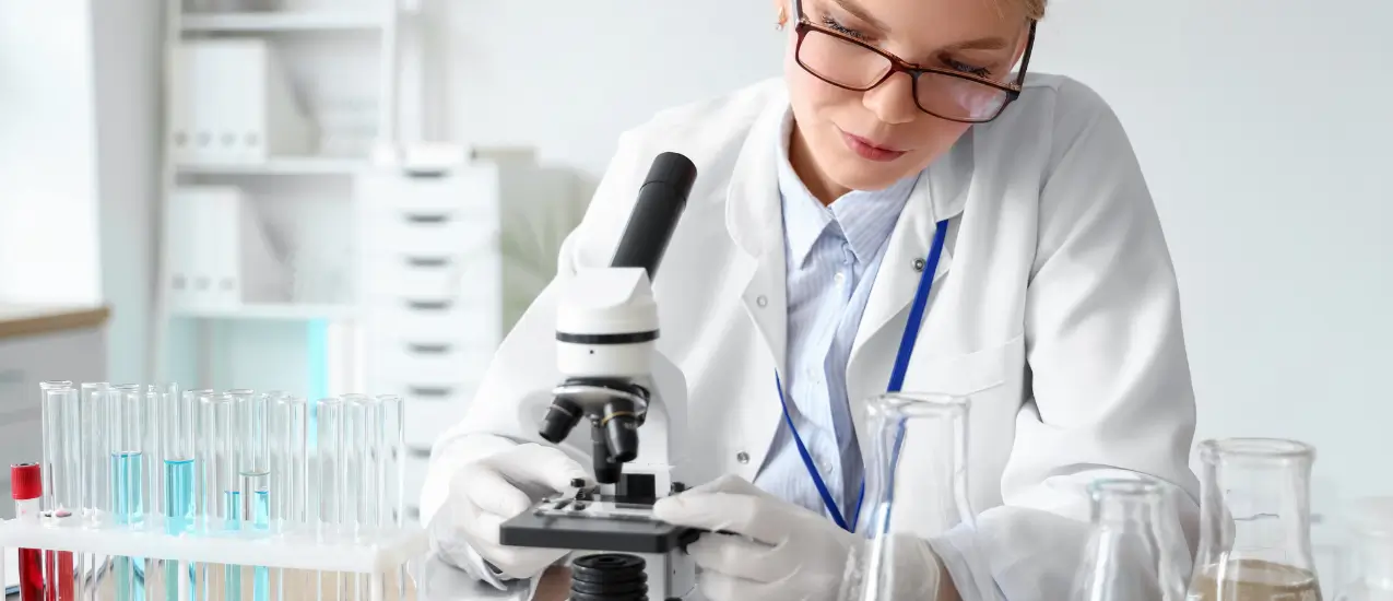 Vědkyně zkoumá vzorky pod mikroskopem v laboratoři.