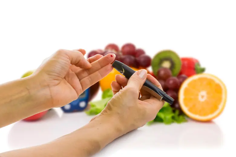 Diabetik měří hladinu cukru v krvi s ovocem na pozadí