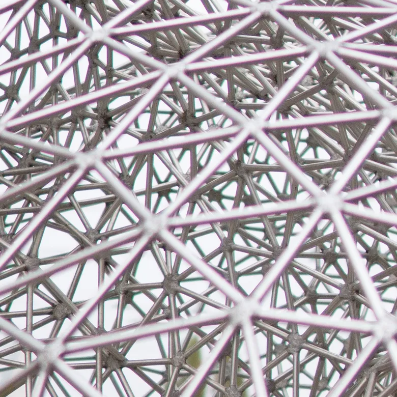 Detail kovové konstrukce tvořící geometrický vzor.