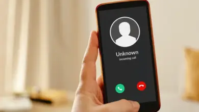 Ruka drží telefon s příchozím voláním od neznámého.