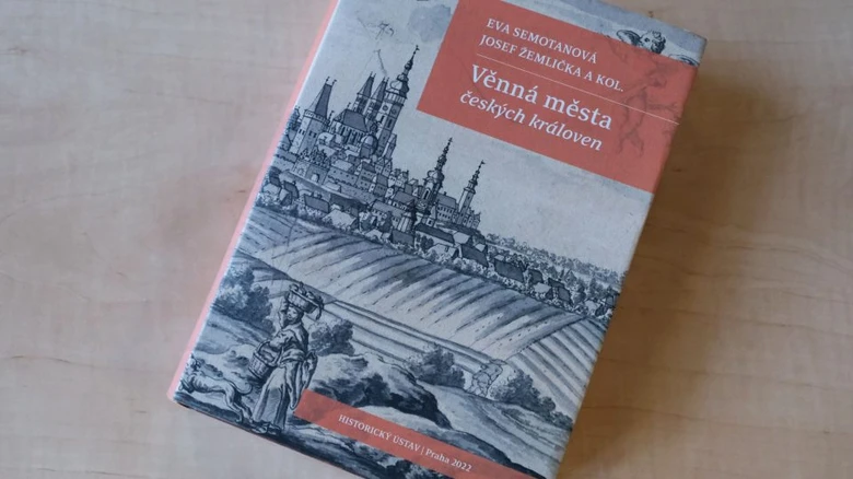 Kniha o městech patřících českým královnám s historickou ilustrací.