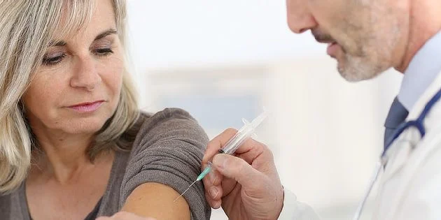Lékař podává očkování zdravotníkovi v českém nemocnici