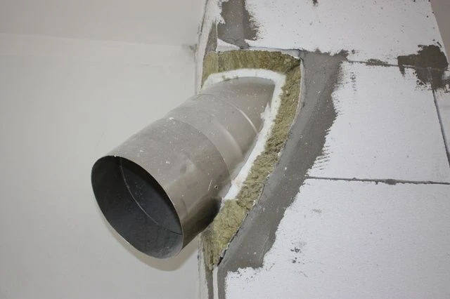 Instalace izolace do komína s viditelnou vložkou a frézovaným otvorem.