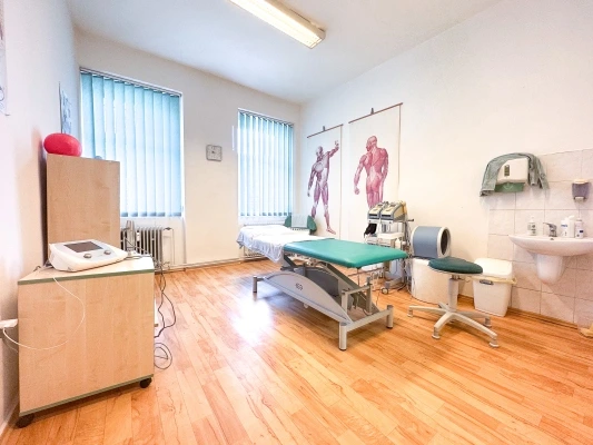 Modern ortopedická ordinace s lůžkem pro vyšetření pacienta.