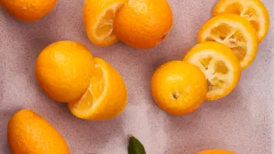 Čerstvé pomeranče a nakrájené citrusy na texturovaném povrchu